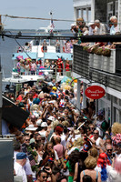 Crowds welcome drag performers arriving by ferry during the annual Invasion of the Pines celebration in Cherry Grove, Fire Island, photographed by Koitz.