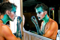 Participant applying dramatic blue and green makeup before the Avatar Invasion of the Pines event in Fire Island Pines, New York, photographed by koitz.