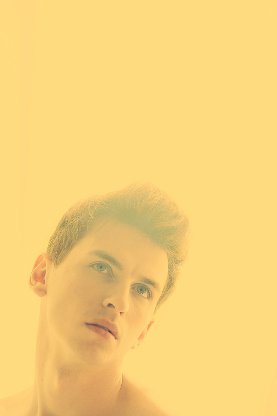 Fine art portrait of a model illuminated by warm yellow light by koitz.