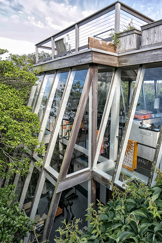 A modernist house in Fire Island Pines designed by architect Horace Gifford, showing the distinctive architectural forms, elevated structure, clean lines, open spaces, and relationship between the res