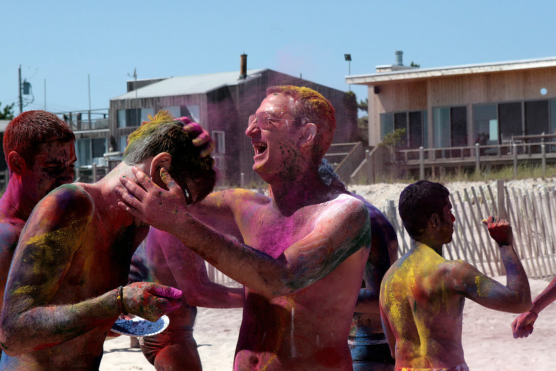 A vibrant Holi celebration on Fire Island Pines beach, captured by koitz Photography in a colorful photograph of the festivities.