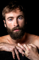 Male model seated on a chair in a contemporary queer fine art portrait by koitz.