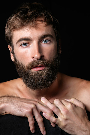 Male model seated on a chair in a contemporary queer fine art portrait by koitz.