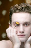 Male model holding flowers in an artistic queer gay portrait by photographer koitz.