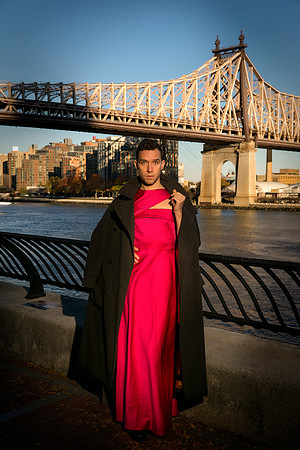 Brock wearing a dress while posing on the 59th Street Bridge in New York City.