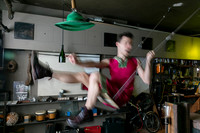 koitz photograph of Brock wearing a dress and seated on a swing, capturing a playful and theatrical moment within Fire Island’s queer visual culture.