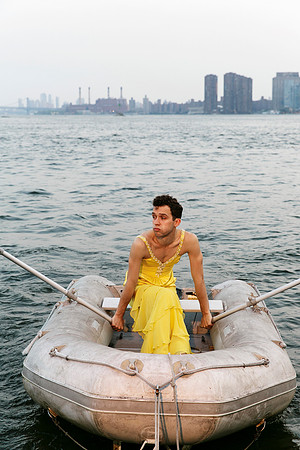 Brock wearing a dress while sitting on a dinghy, photographed by koitz.
