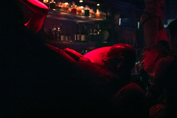 Go-go boy lying on a bar at Bedlam in New York City, photographed by koitz Photography.