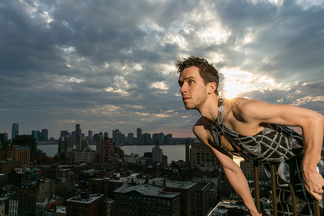 Portrait of Brock wearing a dress on a rooftop with gargoyle sculptures in a contemporary queer photography artwork by koitz.