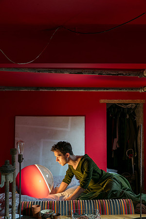 Portrait of Brock wearing a dress while sitting in bed in a contemporary queer photography artwork by koitz.