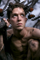 Brock looking up while kneeling on a charred branch in the Meat Rack on Fire Island, photographed by koitz.