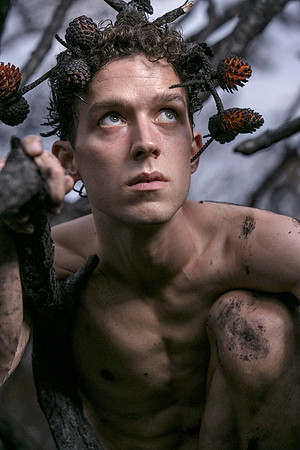 Brock looking up while kneeling on a charred branch in the Meat Rack on Fire Island, photographed by koitz.